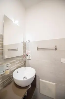 a bathroom with a white sink and a mirror at Villa Amelia in Castellammare del Golfo