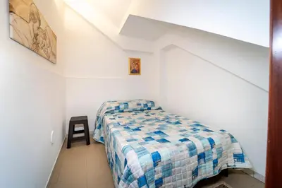 a bedroom with a bed with a painting on the wall at Animami Mare in Castellammare del Golfo