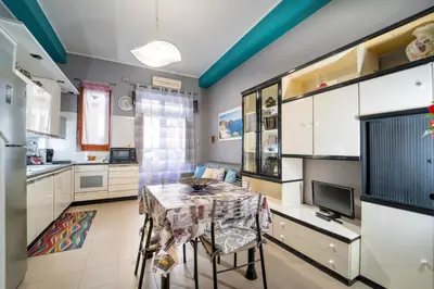 a kitchen with a table with chairs and a television at Animami Mare in Castellammare del Golfo