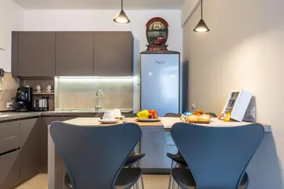 a kitchen with two blue chairs and a table with food on it at Centoquaranta Apartment in Terrasini