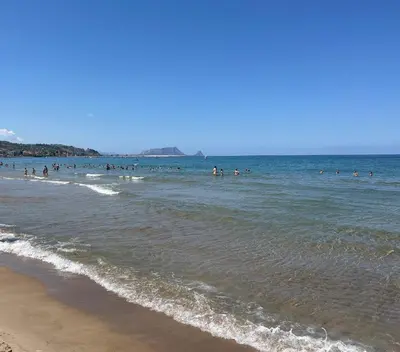 a group of people in the water at the beach at Donna Rosalía Apartments in Trabia