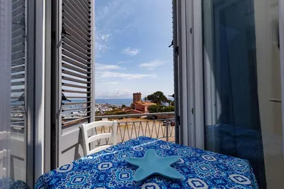 a balcony with a table and a view of the ocean at Donna Rosalía Apartments in Trabia