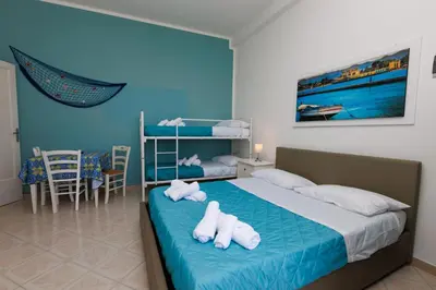 a bedroom with a bed with white towels on it at Donna Rosalía Apartments in Trabia