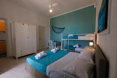 a bedroom with two bunk beds and a blue wall at Donna Rosalía Apartments in Trabia