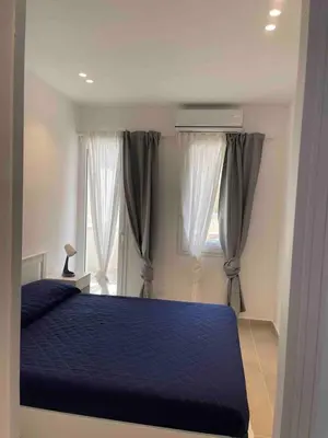 a bedroom with a blue bed and a window at Appartamento sulla Spiaggia in Alcamo