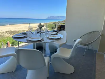 a table and chairs with a view of the beach at Appartamento sulla Spiaggia in Alcamo