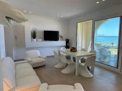 a white living room with a table and chairs at Appartamento sulla Spiaggia in Alcamo