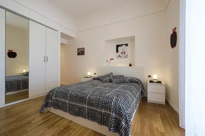 a white bedroom with a bed and two night stands at MAD Bed & Breakfast in Palermo