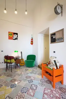 a living room with a table and a green chair at MAD Bed & Breakfast in Palermo