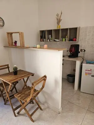 a kitchen with a counter and a table and chairs at Al Maqueda in Palermo