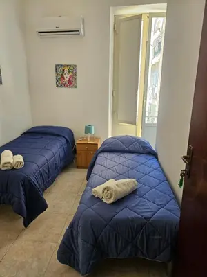 two beds in a room with blue comforters at Al Maqueda in Palermo