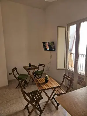 a dining room with tables and chairs and a window at Al Maqueda in Palermo