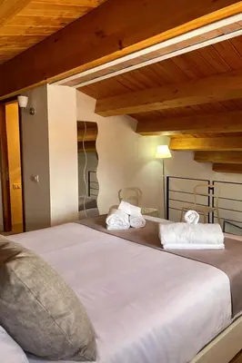 a bedroom with a large bed with wooden ceilings at DhOME Apartment in Palermo