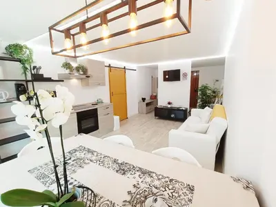 a kitchen and living room with a table and chairs at Domus Sicula Palermo city center in Palermo