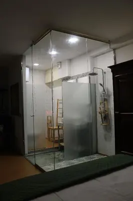 a glass shower in a room with a table at La casa del Cavaliere in Palermo