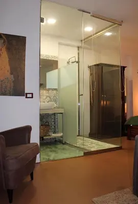 a glass shower in a living room with a couch at La casa del Cavaliere in Palermo