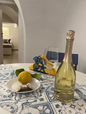 a bottle of wine and a plate of food and a glass at Palazzo dei Duchi D'Amico - Apartment -
