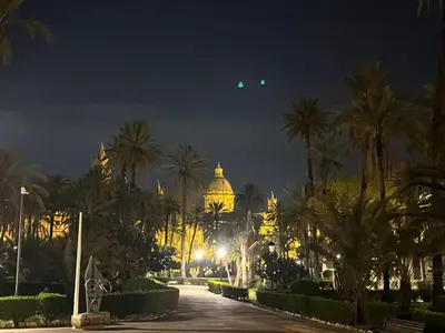 a view of a building with palm trees at night at Palazzo dei Duchi D'Amico - Apartment -
