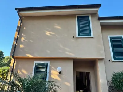 a house with green shutters and a window at Villa Altavilla in Altavilla Milicia