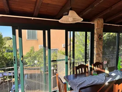 a dining room with glass doors and a table with chairs at Villa Altavilla in Altavilla Milicia