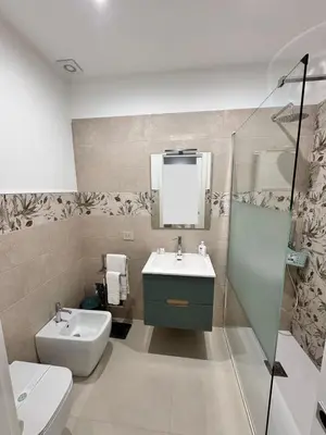 a bathroom with a sink and a toilet and a mirror at Monolocale sotto la torre in San Vito lo Capo