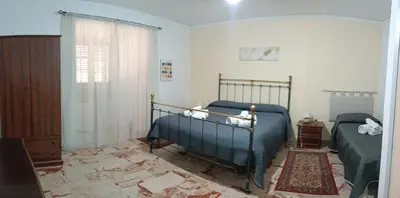 a bedroom with two beds and a window at Beneath the Castle in Corleone