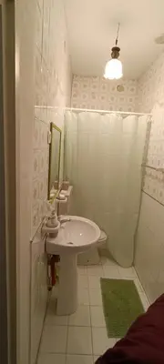 a white bathroom with a sink and a mirror at Beneath the Castle in Corleone