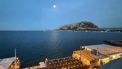 a view of a large body of water at night at Villa Emilia Mondello Appartamento Vita Alba con vista sul mare in Mondello