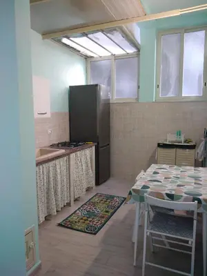 a kitchen with a table and a refrigerator at Casa Ferdinando e Maria in Palermo