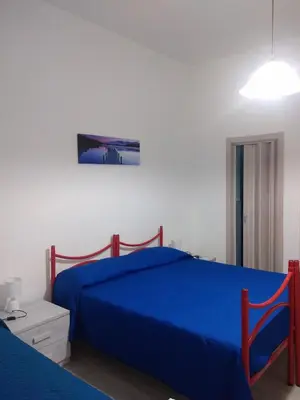 a bedroom with a blue bed and a white wall at Casa Ferdinando e Maria in Palermo