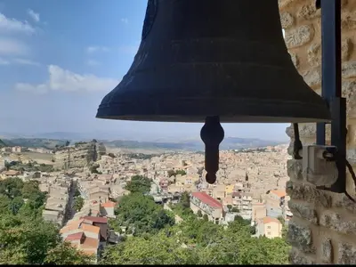 a bell hanging from a tower looking at a city at Corleone bed and breakfast in Corleone