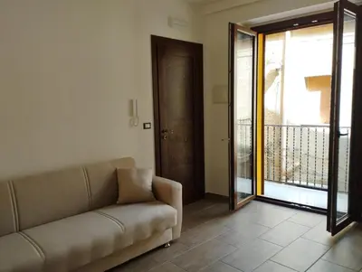 a living room with a couch and a sliding glass door at Corleone bed and breakfast in Corleone
