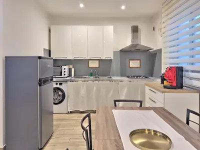a kitchen with a refrigerator and a table with chairs at Casa Belsito in Palermo