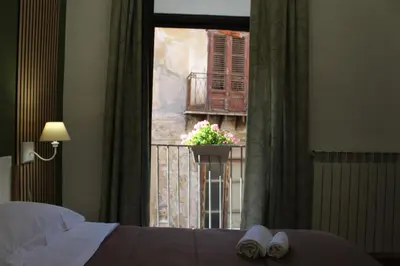 a bedroom with a bed and a window with a balcony at Talitha in Palermo