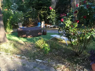 a garden with a hot tub and a chair and flowers at Casa vacanze dispensa San Pietro in Calatafimi