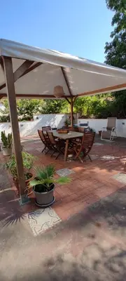 a patio with a table and chairs under a white umbrella at Casa vacanze dispensa San Pietro in Calatafimi