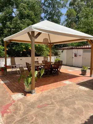 a white umbrella on a patio with a table and chairs at Casa vacanze dispensa San Pietro in Calatafimi