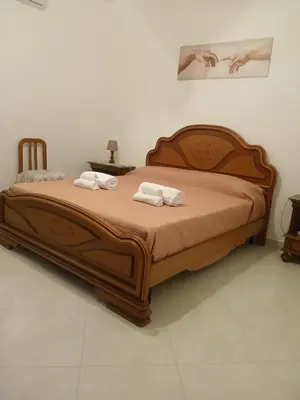 a bedroom with a large bed with two towels at La casetta di Cecilia in Palermo