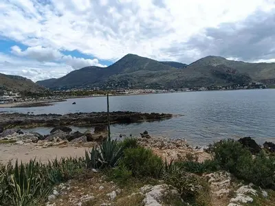 a body of water with mountains in the background at La casetta di Cecilia in Palermo