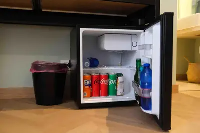 an open refrigerator with drinks and a trash can at Mazzini Suites Palermo in Palermo