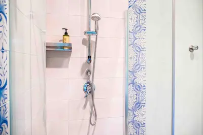 a shower in a bathroom with a shower head at Mazzini Suites Palermo in Palermo