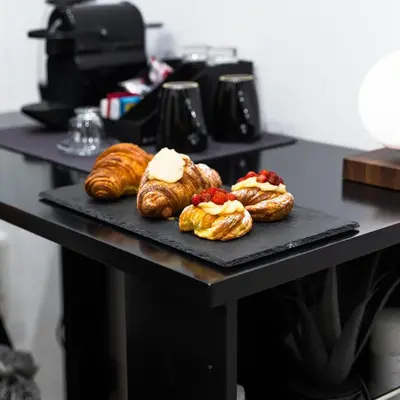 a table with three pastries on a black plate at MEA Suite in Palermo