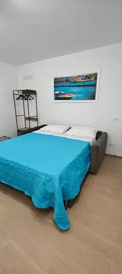 a bedroom with a bed with a blue blanket at Sammartino Apartment in Palermo