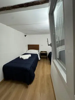a small bedroom with a bed and a window at Sammartino Apartment in Palermo