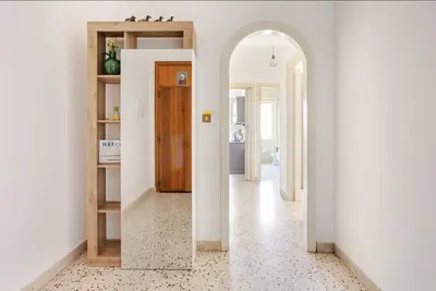 a hallway with white walls and an arched doorway at Dolce Sicily a 1km dal centro in Palermo
