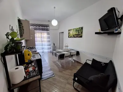 a living room with a couch and a dining room at Tukory Central room Palermo in Palermo