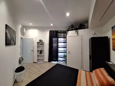 a room with white cabinets and a black refrigerator at Tukory Central room Palermo in Palermo