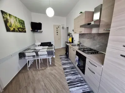 a kitchen with a table and a dining room at Normanni Deluxe Room Palermo in Palermo