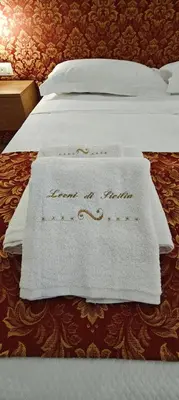 a bed with a white towel on top of it at Leoni di Sicilia in Palermo