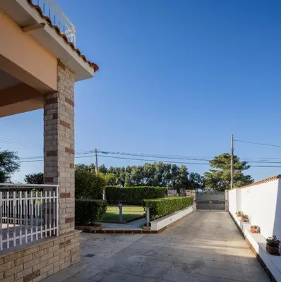 a driveway of a house with a white fence at Villa Yasmine in Cinisi